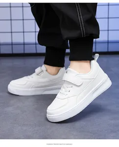 Close-up detail of children's white leather low-top sneakers with velcro straps