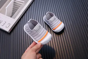 Detailed close-up of grey baby fly-knit walking shoes with orange stripe detail