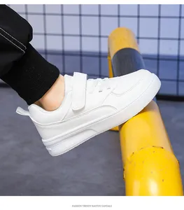 Detail of children's white leather sneakers featuring velcro strap closure.