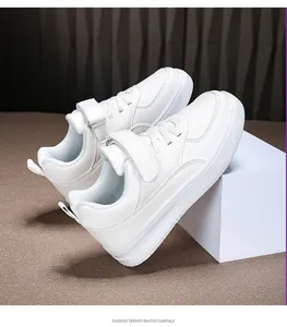 Detailed side view of white children's leather sneakers with adjustable velcro strap