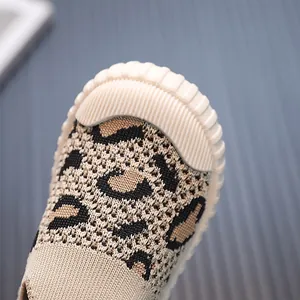 Primo piano di scarpe in maglia leopardata per bambini con suola bianca e morbida
