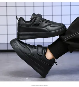 Side view of black children's leather sneakers featuring a secure hook-and-loop strap
