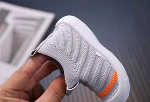 Macro detail of grey breathable knit baby walker shoe with flexible white sole