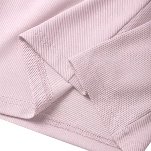Gros plan du tissu côtelé rose montrant les coutures détaillées de l'ourlet d'un gilet