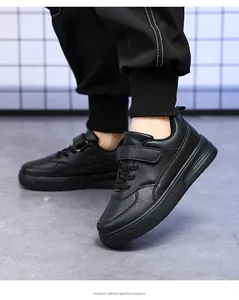 On-foot view of children's black leather casual sneakers with velcro straps.