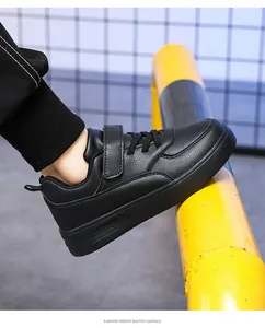 Side view detail of children's black leather low-top sneakers for school and play