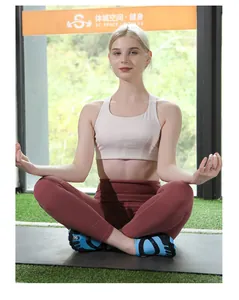 Blonde woman in yoga pose wearing blue five-finger fitness water shoes on a gym mat outdoors