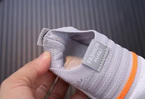 Detail view of grey knit baby walking shoes showing elastic neck and soft lining