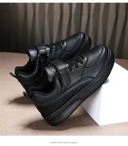 Close-up view of black kids leather sneakers with velcro and lace-up details