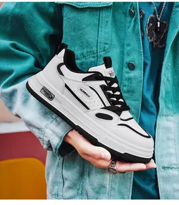 Close-up of trendy white and black men's hip-hop casual skate sneakers held by hand