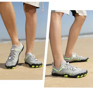 Detailed view of breathable grey water shoes with neon accents being worn on a sandy beach