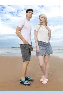 Couple wearing quick-dry five-finger water shoes on a sunny beach for snorkeling.
