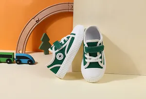 Detail view of green children's canvas walking shoes with velcro straps and toy props