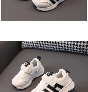 Detailed view of white leather toddler sneakers with black stripes and velcro straps
