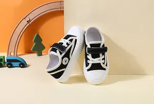 Close-up of black children's canvas sneakers with velcro straps and white soles