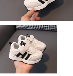 Close-up of white leather children's sneakers with black stripes and Velcro strap