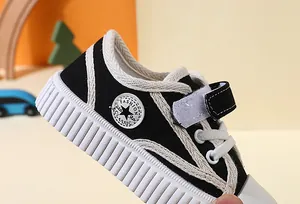 Close-up of children's black canvas shoe with soft rubber sole and velcro strap.