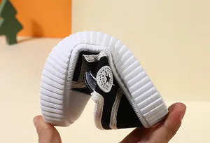 Flexible rubber sole of children's black canvas toddler shoes detail view.