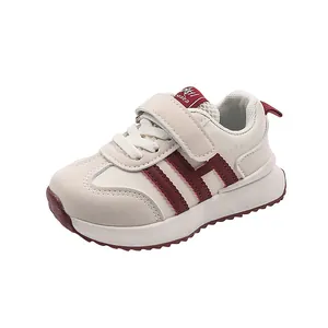 Detailed side view of toddler leather sneaker with burgundy stripes and Velcro strap closure