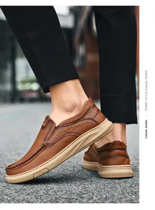 Detail van bruine echt lederen loafers met stikseldetails en een profielzool.