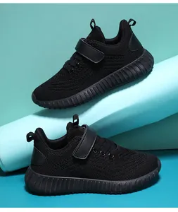 Détail en gros plan de baskets en mesh noir respirant pour garçons et filles avec velcro