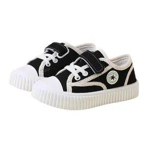 Classic black and white toddler canvas shoes with soft soles and velcro straps.