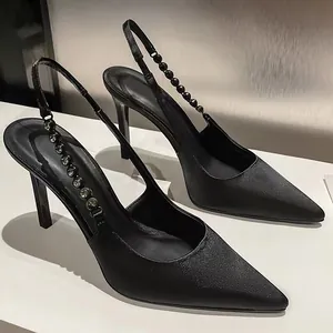 Side view of elegant black pointed toe slingback heels featuring rhinestone strap detail