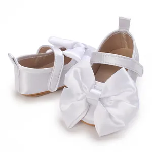 Elegantes zapatos de bebé en satén blanco con grandes lazos y suelas blandas de princesa