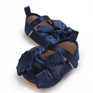 Primer plano de zapatos de princesa para bebé azul marino con un gran lazo de raso y suela