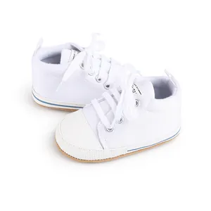 Detalle de zapatos de lona blanca para bebés y niñas que aprenden a caminar de 0-1
