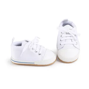 Close-up detail view of white newborn canvas walker shoes with soft rubber soles for babies