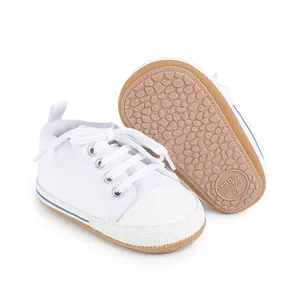 Vista detallada de zapatos de lona blancos para bebés con suelas de goma antideslizantes