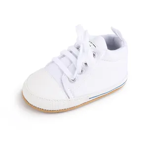 Vista lateral de una zapatilla clásica de lona blanca para bebé con suela blanda