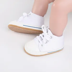 Detailed view of white newborn canvas shoes featuring non-slip rubber soles and laces