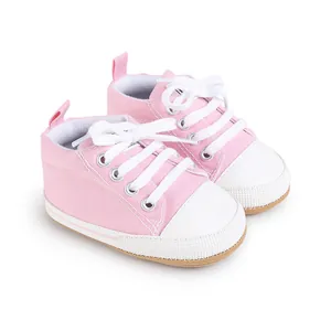 Primer plano de zapatos de lona rosa para bebés con cordones blancos y puntera blanca