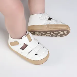 Detailansicht weißer Baby-Sommersandalen mit braunem Besatz und rutschfesten Sohlen