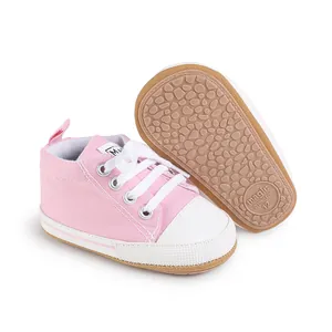Detalle de zapatos de lona rosa para bebé con suela de goma antideslizante texturizada