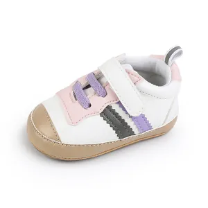Dettaglio laterale di scarpa da neonato in pelle morbida con inserti rosa e viola