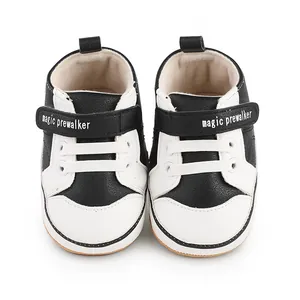 Close-up front view of black and white baby pre-walker shoes with adjustable velcro straps