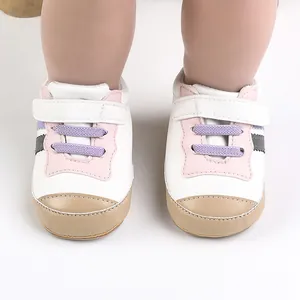 Dettaglio frontale di scarpine primi passi bianche con inserti rosa e viola per neonati