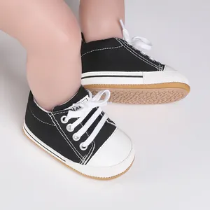 Vista detallada de zapatos de lona blancos y negros para bebés con suelas antideslizantes