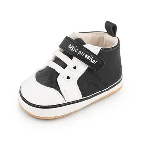 Detail of black and white synthetic leather baby pre-walker shoes with velcro strap
