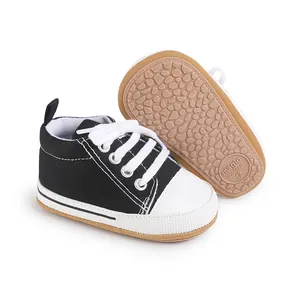 Primer plano de zapatos de lona negros clásicos para bebés con suela de goma antideslizante