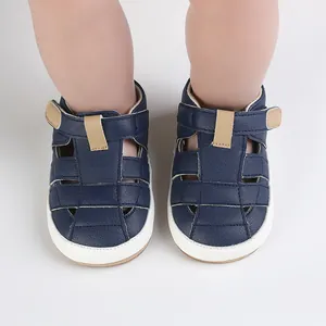 Detailansicht von dunkelblauen Baby-Sommersandalen, getragen von einem Kleinkind.