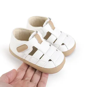 Close-up of white soft-soled baby toddler shoes held in hand
