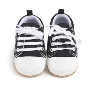 Detailed front view of black canvas infant walking shoes with white laces and toe caps