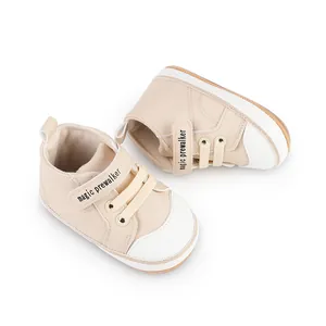 Detail view of beige baby prewalker shoes featuring magic prewalker text on the velcro strap.