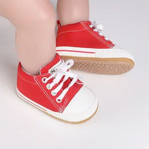 Primer plano detallado de zapatos de lona roja para bebé con cordones blancos y puntera