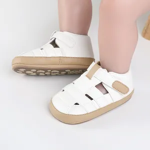 White and tan leather baby walking shoes with cut-out details and velcro strap