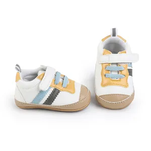 Dettaglio di scarpe da camminata per neonati in bianco con accenti gialli e azzurri